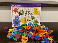Wooden jigsaw puzzle board with colourful magnetic letters scattered