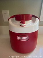 Front view showing Thermos logo, red body, white collar, spout and handle