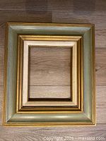 Front view of frame showing green and gold finish and linen liner
