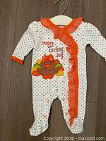 Full view of footed sleeper on hanger showing pattern, applique and size