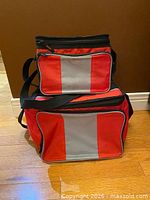 Front view of both nesting red and gray soft-sided coolers