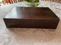 Closed wooden cutlery box showing exterior wear