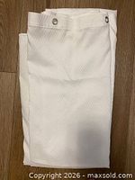 Folded white shower curtain full view