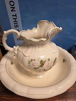 pitcher on basin front view showing rose decoration and gilded rim