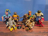 Group shot showing all eight figures, small red companion, and turtle shell accessory