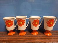 Set of four matching pedestal mugs lined up