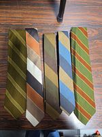 Front view of five narrow striped neckties laid flat showing color and pattern