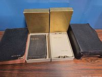 All four bibles displayed with two gold slipcases and white trays