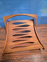 Front view of folded teak tray showing cut-out slat design