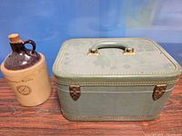 Stoneware jug and green train case side by side