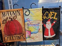 Three polyester garden flags on black metal stakes: pumpkin autumn, beach pail, Santa NOEL