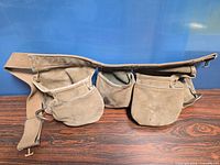 Front view of suede tool belt showing four pouches and adjustable strap