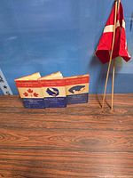 Front view of three WWII Canadian Army at War books standing, Danish flag folded on staffs