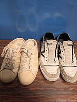 Both pairs of sneakers side by side on floor
