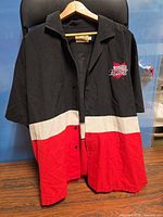 Full front view of color-block button-up shirt on hanger