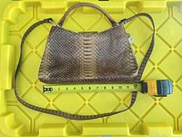 Front view of handbag with measuring tape showing width approx 11.5 inches