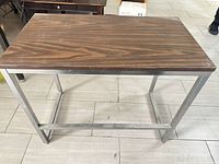 Full view of rectangular side table showing wood top and metal frame