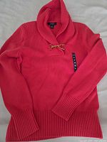 Red knit sweater with shawl collar and clasp, long sleeves, size label M visible