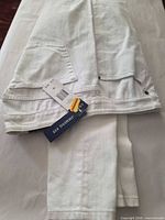Folded white Chaps jeans with attached retail and size tags visible