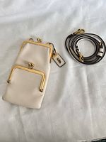 Front view of Coach phone pouch showing gold-tone kiss-lock closures, leather hangtag and separate strap