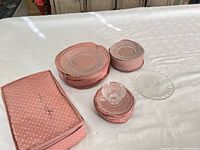 overview of all glass pieces inside and beside their pink storage cases on table