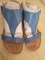 Top view of both denim wedge sandals with tissue inserts visible