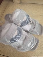Pair of Donald J Pliner slide sandals wrapped in plastic with stuffing visible