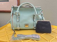 Front view of mint Dooney & Bourke satchel with wrapped detachable strap and black coin purse