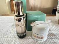 Serum bottle, cream jar with spatula, both retail boxes visible