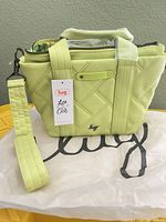 Front view of Lug lime quilted bag with hang tag and dust bag