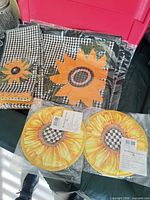 Two rectangular placemats and two round potholders in plastic packaging