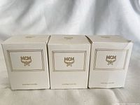 Three boxed MCM candles front view