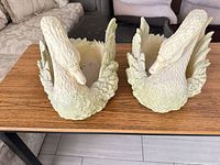 Top view of both resin swan planters showing hollow centers and feather detail