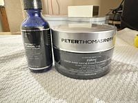 Front view of serum bottle and Firmx cream jar