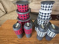Full lot showing 3 travel mugs and 8 stackable cups with lids on table