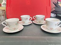 Four matching fine porcelain teacups each on its coordinating saucer, all showing Rose Garden floral design