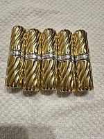 Five closed gold-tone tubes aligned front view