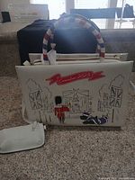 Front of tote showing Coronation 2023 print, tricolour handles, attached pouch