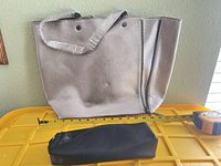 Front view of tote with measuring tape and black accessory piece