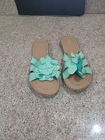 Top view of both mint/aqua slide sandals showing floral embellishments and footbeds