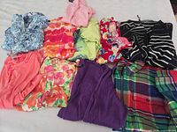 Overview of 10 women’s tops and blouses laid out on surface