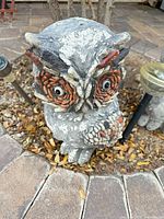 Front view of one owl statue showing face and feather detail