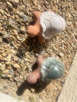 Top view of both terracotta turtle statues on gravel
