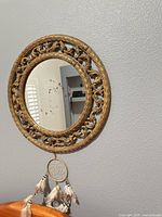 Full view of mirror on wall with dreamcatcher hanging