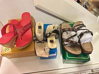 Three pairs of sandals on boxes showing overall lot