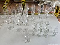 Full set of assorted clear stemmed glasses on table