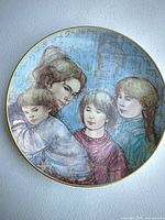 Front view showing artwork of mother and children and gold rim