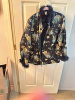 Full view of black floral jacket hanging on door