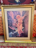 Front view of framed print showing image, frame, tape measure for width