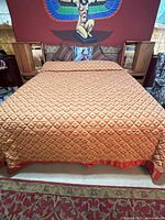 Full view of king bed with comforter and headboard storage